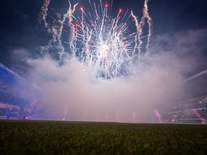 Großes Feuerwerk mit dichtem Rauch über dem Spielfeld vor beleuchteten Tribünen